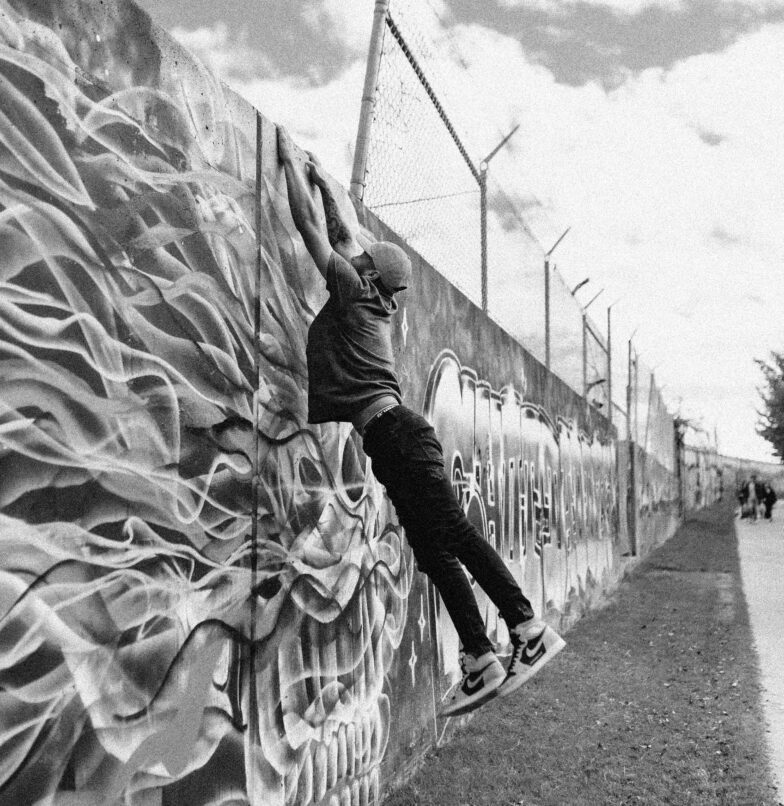 Artist hanging from graffiti wall in Phoenix, AZ.