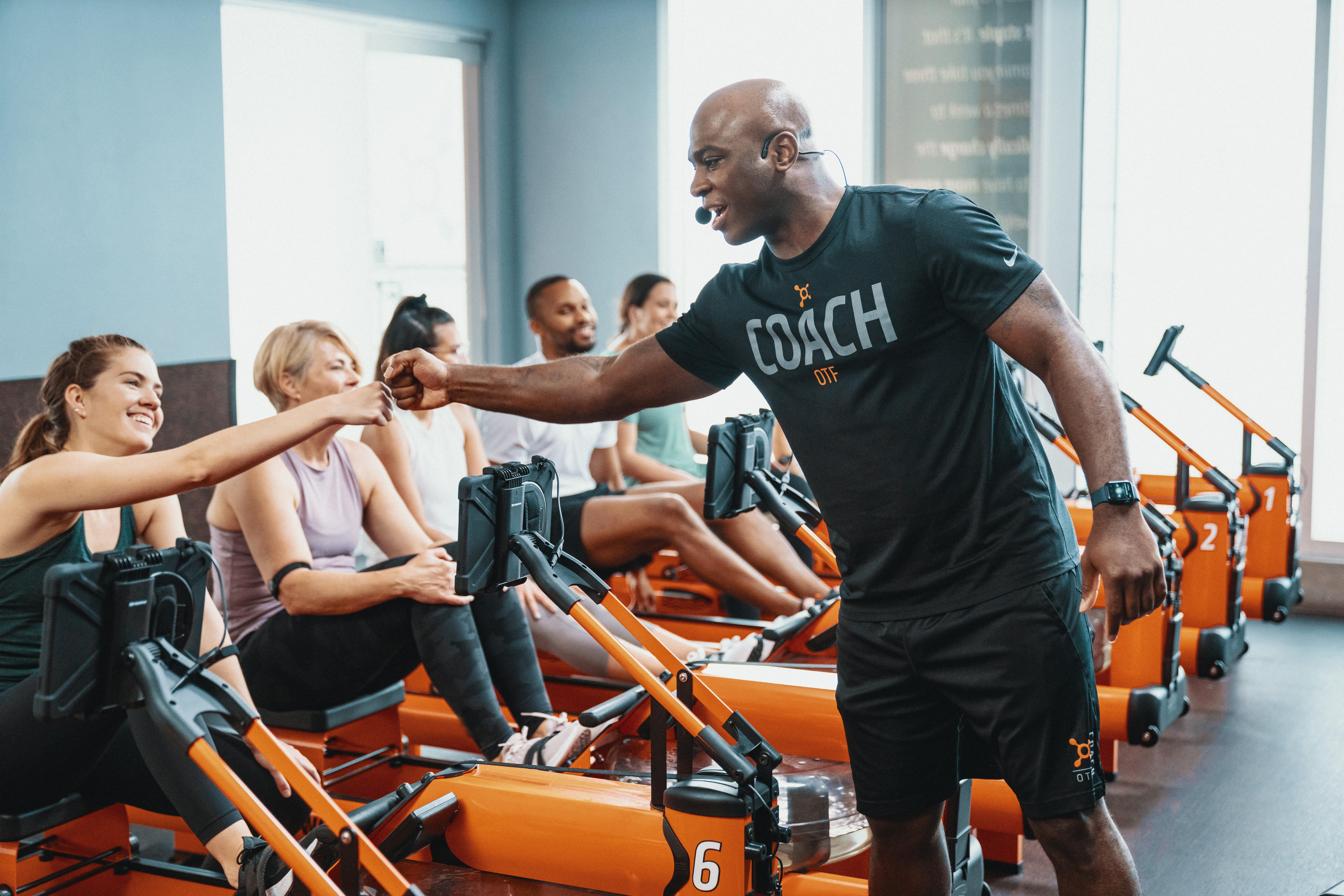 Orange theory trainer fist bumps client