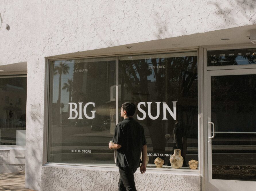 A man walks down the street in front of Big Sun health store in downtown phoenix